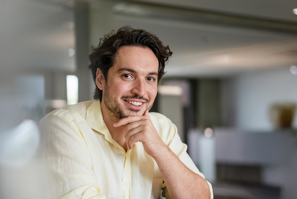 Mann im hellgelben Hemd, der sich nachdenklich ans Kinn fasst