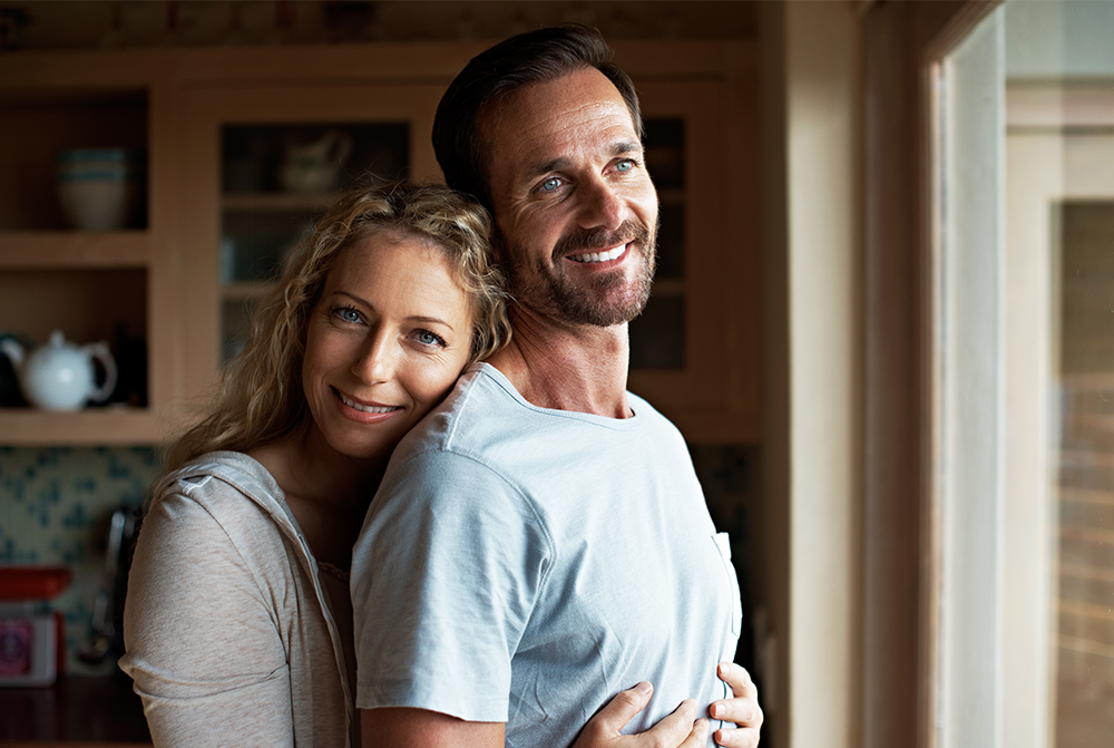 Frau, die einen Mann von hinten umarmt