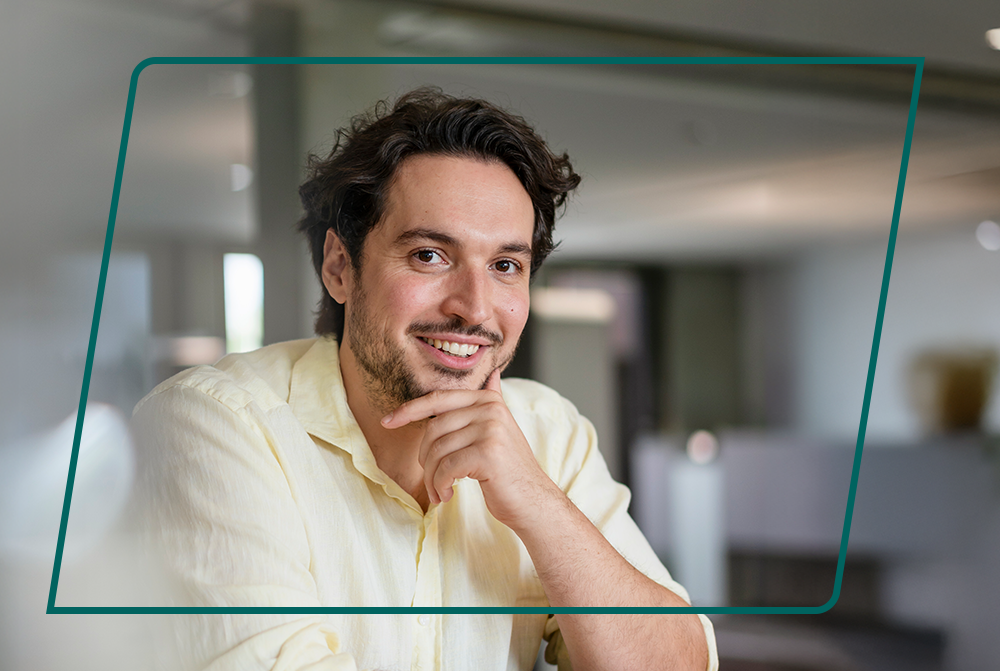 Mann im helgelben Hemd, der sich nachdenklich ans Kinn fasst